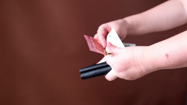 Weibliche Hand Öffnet Ein Schwarzes Portemonnaie Auf Dunkelbraunem Hintergrund Bekommt — Stockvideo
