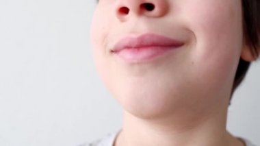 Küçük çocuk, çocuk ağız için eklem egzersizleri yapıyor, dili tüpe sokuyor, ağız boşluğu, yakın çekim, vokal, diş konsepti, konuşma terapisi.