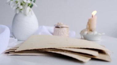 İlk bahar çiçekleri, kartanesi, vazodaki Galanthus, bir melek figürü, bir yığın eski fotoğraf, mum, aile ağacı konsepti, soy ağacı, atalarımızın hafızası.