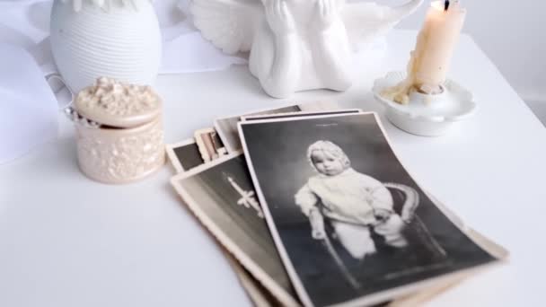 成堆的老式照片 1960年的婴儿摄影 点燃的蜡烛 初春的花朵 花瓶里的石榴 童年的回忆 — 图库视频影像