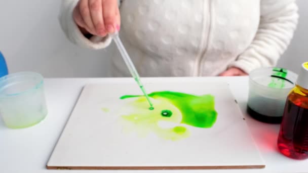 Žena Aplikuje Zelenou Barvu Pipetou Nafoukne Abstraktní Skvrny Rozprostřené Bílém — Stock video