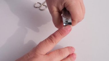 Kırışıklıklar içinde yaşlı bir kadının elleri, makas, makas, tırnak kesme, bakım, evde manikür, güzellik ve spa prosedürleri kavramı.