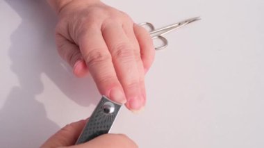 Kırışıklıklar içinde yaşlı bir kadının elleri, makas, makas, tırnak kesme, bakım, evde manikür, güzellik ve spa prosedürleri kavramı.