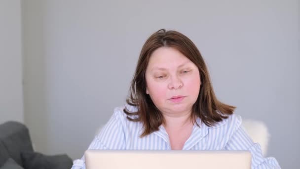 Ηλικιωμένη Γυναίκα Ελαφριά Μπλούζα Κάθεται Στο Σπίτι Μπροστά Από Την — Αρχείο Βίντεο