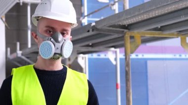 İnşaat alanında inşaat işçisi, işçi ya da mimar olarak çalışan genç erkek inşaatçının inşaat planlarını, binaların onarımını, yapıların onarımını izleme kavramını elinde tutuyor.