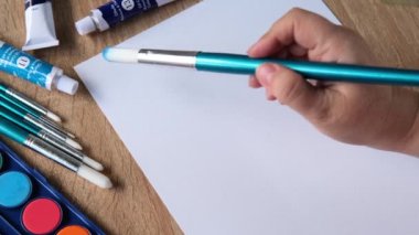 Kadın ressamın eli, renkli boyalar, mavi çizgiler, arka plan, beyaz desenli kağıda yayılmış soyut noktalar, suluboya resim, yaratıcı sanat konsepti, sanat terapisi