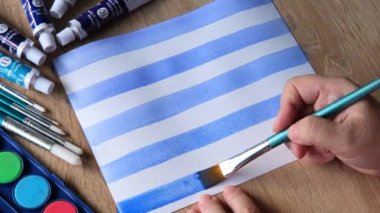 Kadın ressamın eli, renkli boyalar, mavi çizgiler, arka plan, beyaz desenli kağıda yayılmış soyut noktalar, suluboya resim, yaratıcı sanat konsepti, sanat terapisi