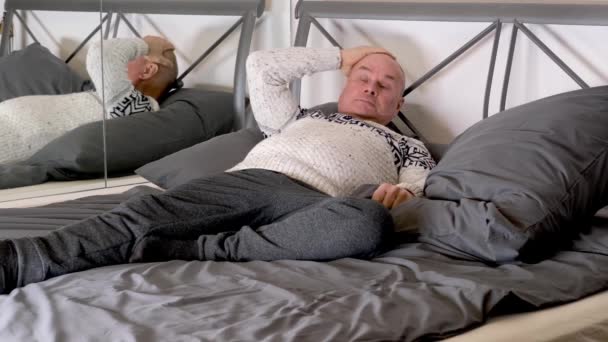 Poważny Łysy Mężczyzna Skandynawskim Pulowerze Leży Domu Łóżku Odpoczywa Pracy — Wideo stockowe