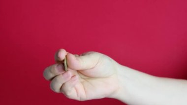 Kadın elleri kırmızı arkaplanda 1 avro tutarken, bir tomar para, nakit, ödeme, tasarruf ve AB ülkelerinden alışveriş kavramları sayılıyor