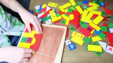 çocuk, çocuk renkli ahşap küplerle oynar, evler ve roketler yapar, yaratıcılığın gelişimi, iyi motor beceriler, sabır ve azim kavramı