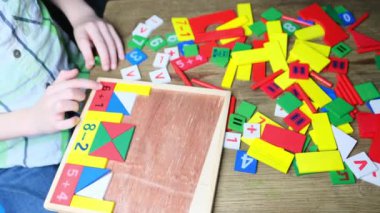 çocuk, çocuk renkli ahşap küplerle oynar, evler ve roketler yapar, yaratıcılığın gelişimi, iyi motor beceriler, sabır ve azim kavramı