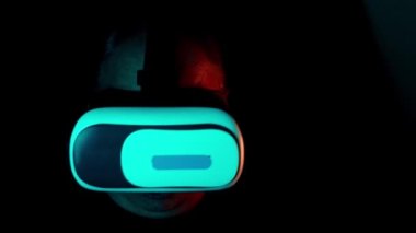 Modern sanal gerçeklik deneyimi, paralel gerçeklik konsepti çalışması, başka bir dünya ile etkileşime girerken modern VR gözlüklü, neon ışıkları olan karanlık bir odada orta yaşlı bir adam.