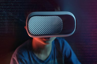 Çocuk, karanlık odada, modern VR gözlüklü bir çocuk sanal gerçeklik deneyimi, başka bir dünyanın konsept çalışması, modern öğretim teknolojileri ile etkileşime geçiyor.