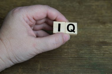 Kadın elinin IQ 'su, ahşap arka plandaki zeka miktarı, başarıyı ifade eden nicel gösterge, zihin seviyesi konsepti, bir insanı düşünmek, entelektüel başarılar.