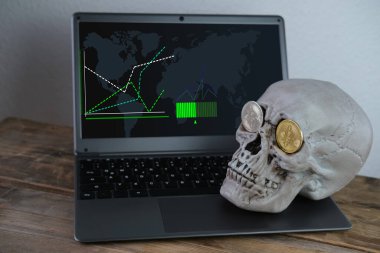 Klavyede insan kafatası, göz yuvalarında metal bitcoin, kripto para madenciliği konsepti, yaşamın geçişi, ölümün kaçınılmazlığı, parasal işlemlerin riski