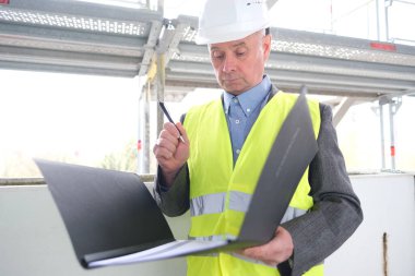 Deneyimli yaşlı inşaatçı, inşaat ekibi lideri, beyaz kask koruma mühendisi inşaat sahasında inşaat yenileme, inşaat mühendisliği konsepti belgeleri imzaladı.