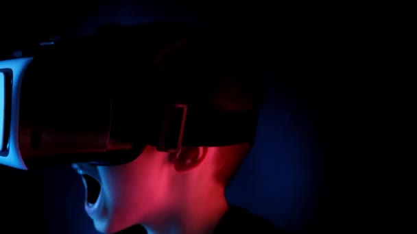 黑暗房间里的孩子 戴着霓虹灯 戴着现代Vr眼镜 与网络互动 同时拥有虚拟现实的经验 对另一个世界的概念研究 现代教学技术 — 图库视频影像