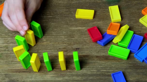 Close Mão Criança Constrói Linhas Dominós Cubos Coloridos Dominós Cair — Vídeo de Stock