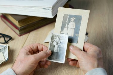 closeup male hand holding old vintage photos of 1940-1950, concept of family tree, genealogy, childhood memories, memory of ancestors clipart