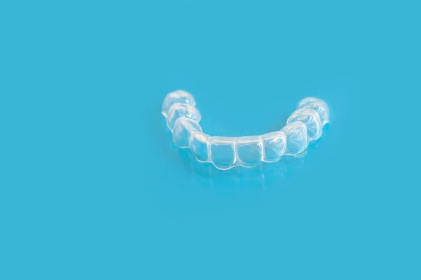 硅胶夜间牙齿咬合护齿的特写牙床蓝底咬牙安眠药 概念牙科服务 磨牙治疗 口腔护理 — 图库照片