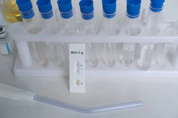 antigenic test cassette, glass test tubes with reagents, conducting a rapid test covid-19 in a medical laboratory, concept of early detection of a viral disease