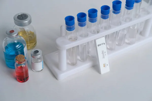 antigenic test cassette, glass test tubes with reagents, conducting a rapid test covid-19 in a medical laboratory, concept of early detection of a viral disease