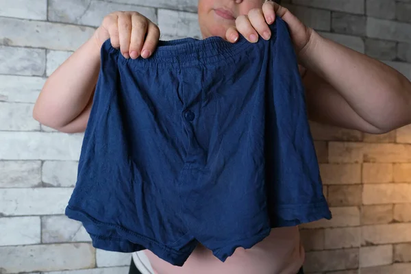女人手里拿着蓝色男人的内裤 编织内裤 舒适服装的概念 在俄罗斯联邦安全局的丑闻 — 图库照片