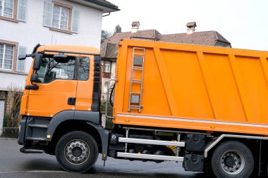 LUCERNE caddelerinden geçen turuncu kargo çöp kamyonu, SWitzERLAND, çöp kutularından çöp toplama, atık geri dönüşüm konsepti, caddelerde trafik güvenliği düzenlemesi kavramı