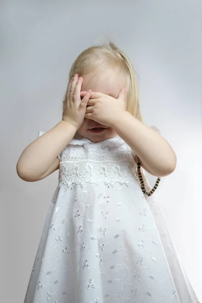 Małe Dziecko Nieśmiała Dziewczyna Białej Sukience Zakryła Twarz Dłońmi Niegrzeczna — Zdjęcie stockowe