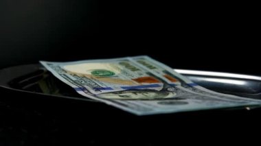 Fatura ve bahşiş içeren metal tepsi, siyah arka planda Amerikan doları, yavaş çekim rotasyonu, seçici odak, restoran, kafe öğle yemeği konsepti, iyi hizmet için garsona bahşiş parası