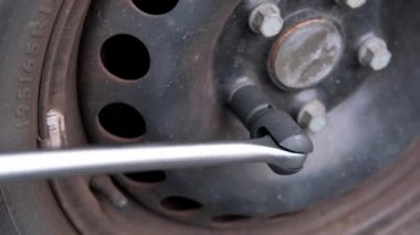 Araba diski yakın çekim, atölyede araba tekerleği değiştirme, kendi kendine servis lastiği uydurma konsepti, usta tekerlek fındıklarını sıkmak için profesyonel anahtar kullanıyor.