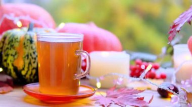 Yeşil çay bardağını kaplamalı, çay tabağının üstünde, ahşap masa üzerinde, balkabağı yalanı, mumlar yanıyor, sabah konsepti, mevsimlik sonbahar havası, sağlıklı yaşam tarzı.