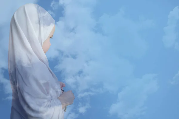 罪のない小さな子供 青い空に対する白いヒジャーブの少女 白いドレスとヒジャーブのイスラム教徒の少女 全能のアッラーへの祈り 真の信仰の概念 雲との二重暴露 — ストック写真