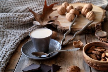 Bir fincan kahve, farklı türde fındık, ceviz, fındık, eski ahşap masa tahtalarındaki badem, yenilebilir çekirdek, gıda konsepti, şekerleme malzemesi.