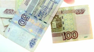 Rusya Federasyonu 'nun kağıt banknotları, yukarıdan masaya düşen Rus rublesi, dağınıklık, yavaş çekim, bankacılık işlemleri, devalüasyon kavramı.