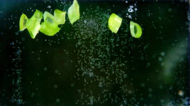 yeşil kesilmiş aloe vera yaprağı suya düşer, hava kabarcıkları yükselir, doğal tıp konsepti, cilt ve saç bakımı için kozmetik ürünleri, yavaş çekim