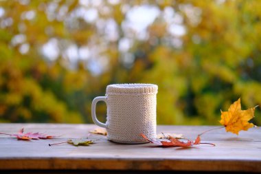 içecek, fincanda kahve, yapraklar, bahçedeki ahşap masada yapraklar, arka planda güzel bulanık doğal manzara, iyi hava konsepti, açık hava çay partisi, sıcak sonbahar havası.