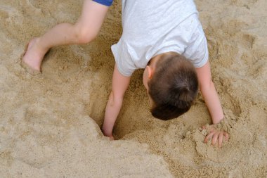 Çocuk yaz aylarında oyun alanında, kum havuzunda, güzel motor becerilerin, yaratıcılığın, kumdan kaleler inşa etmenin, yaz tatilinin, sahilde eğlencenin gelişimi konseptiyle oynar.