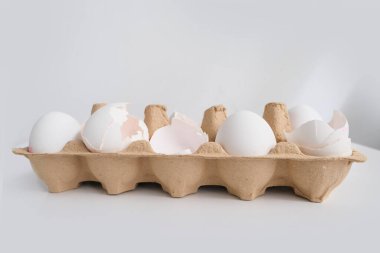 Beyaz masadaki bir tepsi beyaz yumurtaya yakın çekim, ev için ürün alma konsepti, ev yemeği malzemesi, Paskalya yumurtası boyası.