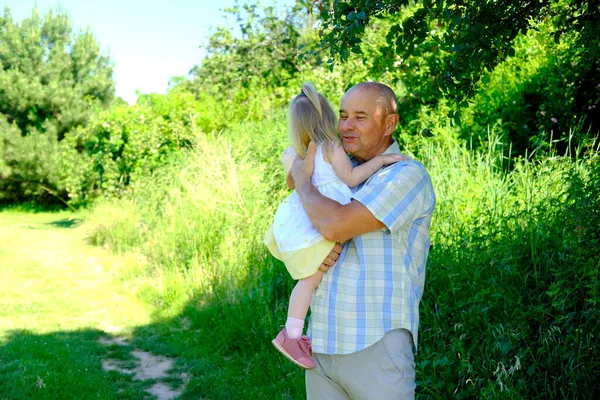 Elderly Bald Tanned Man Holds His Arms Hugs His Small — Stock Photo, Image