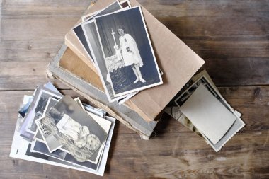 Eski fotoğraf yığınları, 1940-1950 yılları arasında tahta masa, eski kitaplar, soy ağacı konsepti, atalarımızın hafızası, aile ağacı, soy ağacı, çocukluk anıları, aile arşivi.