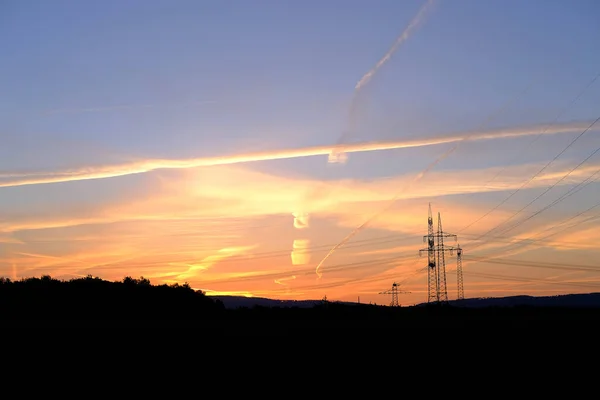 Piękny Krajobraz Niebo Liniami Szlaku Lotniczego Wieże Energetyczne Pole Wieczorem — Zdjęcie stockowe