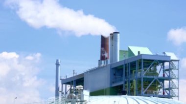 Büyük fabrika, modern kimyasal üretim, borulardan mavi gökyüzüne duman sinekleri, buhar, çevresel kirlilik konsepti, atmosfere zararlı emisyonlar