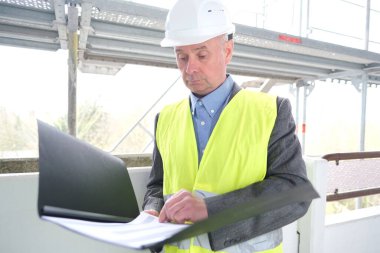 Deneyimli yaşlı inşaatçı, inşaat ekibi lideri, beyaz kask koruma mühendisi inşaat sahasında inşaat yenileme, inşaat mühendisliği konsepti belgeleri imzaladı.