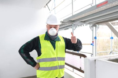 Neşeli kıdemli erkek ustabaşı, beyaz kazaklı işçi, inşaat alanında iş kıyafetleri, çılgın işçiler, bina onarımı konsepti, yapılar.