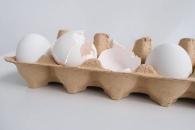 Beyaz masadaki bir tepsi beyaz yumurtaya yakın çekim, ev için ürün alma konsepti, ev yemeği malzemesi, Paskalya yumurtası boyası.