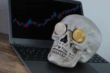 Klavyede insan kafatası, göz yuvalarında metal bitcoin, kripto para madenciliği konsepti, yaşamın geçişi, ölümün kaçınılmazlığı, parasal işlemlerin riski