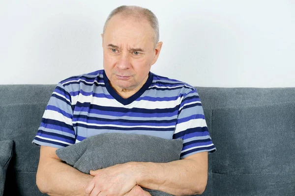 Viejo Hombre Calvo Sentado Sofá Presionando Una Almohada Estómago Cara — Foto de Stock