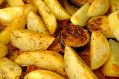 İştah açıcı patatesler, fırında pişmiş patlıcan dilimleri, fırın tepsisinde yatmalar, ev yemeği konsepti, geleneksel yemekler.