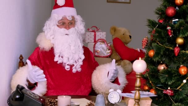 Санта Клаус Традиційному Червоному Костюмі Білою Бородою Сидить Біля Прикрашеної — стокове відео
